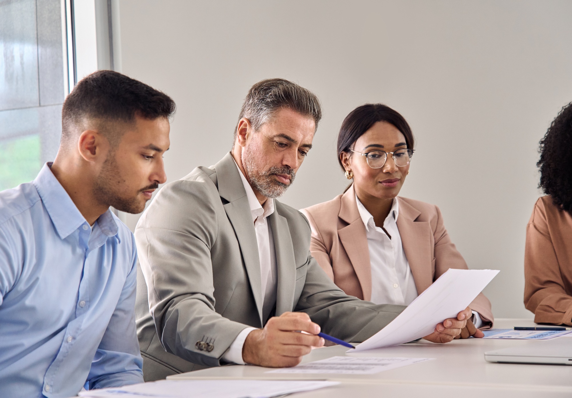 Serious business man checking document at meeting with financial law experts.